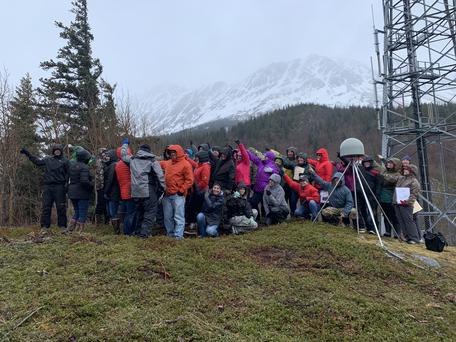Workshop participants at GPS station AC20 near Girdwood, AK showing the direction of plate motion.