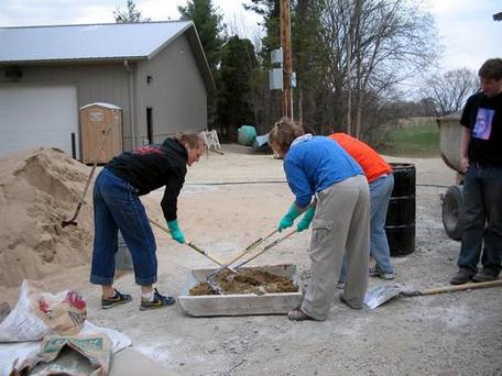 Eco-house students mixing plaster Carleton College