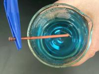 copper sulfate solution in beaker with nail and copper precipitate