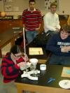 student pouring acid into crushed malachite to extract copper